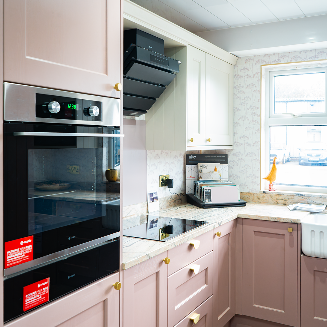 Pink shaker kitchen with gold handles